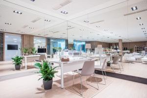 a conference room with white tables and chairs and plants at Melia Sitges in Sitges