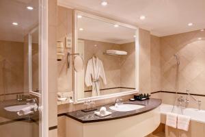 a bathroom with a sink and a tub and a mirror at Sofitel Budapest Chain Bridge in Budapest