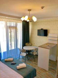 une chambre d'hôtel avec un lit, une table et une cuisine dans l'établissement White-House, à Ureki