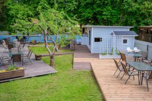 a backyard with a wooden deck and a table and chairs at Cabin Guesthouse with free parking in Pärnu