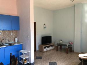a kitchen with blue cabinets and a tv in a room at Apartment JELENA in Senj