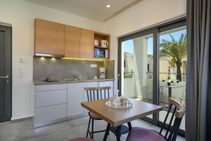 a kitchen with a table and chairs in a room at Athina Suites Platanias in Platanias