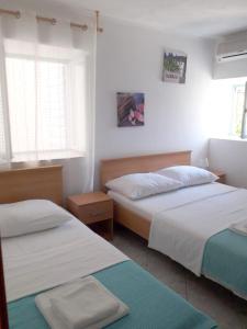 una camera con due letti e due finestre di Apartments Rejo a Okrug Donji