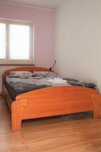 een bed met een houten frame in een kamer bij Apartment Olivia in Čiginj