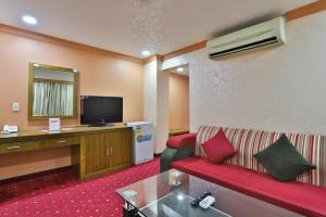 a hotel room with a couch and a television at فندق قصر الخبر in Al Khobar