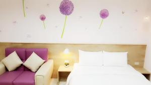 - une chambre avec un lit et un canapé violet dans l'établissement Wei Yu No.1, à Tainan