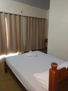 een slaapkamer met een groot wit bed en een raam bij Praia do Jatobá in Sao Jorge