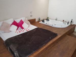 Una cama con almohadas y una bañera en una habitación. en Heaven Guesthouse, en Corbeni