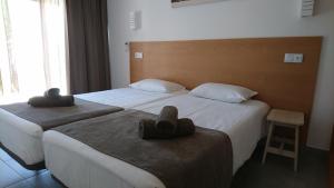 two beds in a hotel room with hats on them at Bayside Salgados in Albufeira