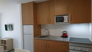 a small kitchen with a sink and a microwave at Bayside Salgados in Albufeira