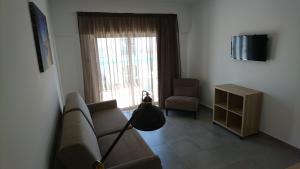a living room with a couch and a chair and a window at Bayside Salgados in Albufeira