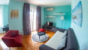 a living room with a couch and a red chair at Apartments Neda in Kampor