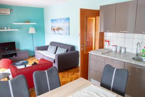 a kitchen and a living room with a couch at Apartments Neda in Kampor