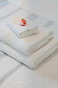 a stack of white towels with a strawberry on top at 20 River Club Villas in Plettenberg Bay