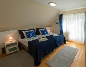 a bedroom with a bed, desk, and nightstand at Airport Apartman in Vecsés