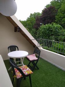 een patio met 2 stoelen en een tafel op een balkon bij Cocon proche Paris - CDG in Aulnay-sous-Bois