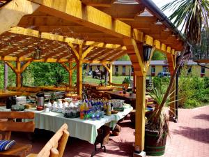 a table under a wooden pergola with tables and chairs at -Waldhaus-Fewo 4 in Granzow