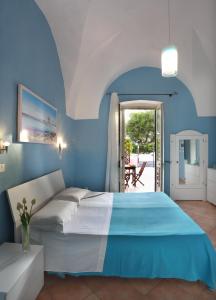 una camera blu con un letto e una porta che conduce a un patio di B&B Happy Days Golfo di Gallipoli a Santa Maria al Bagno