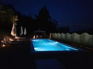 una piscina en un patio trasero por la noche en Cascina Ghitin Relais, en Asti