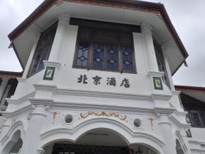 un bâtiment blanc avec des écrits chinois sur lui dans l'établissement Hotel Peking, à Taiping