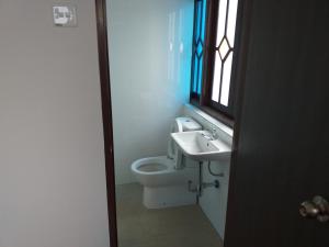 a bathroom with a toilet and a sink and a window at Hotel Peking in Taiping