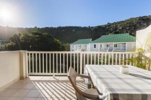 a patio with a table and chairs on a balcony at 20 River Club Villas in Plettenberg Bay