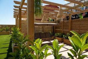 a patio with a chair under a wooden pergola at MAISON MOMA in Palafrugell
