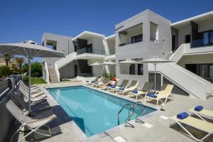 a villa with a swimming pool with chairs and umbrellas at Athina Suites Luxury Suites Near The Sea Platanias in Platanias