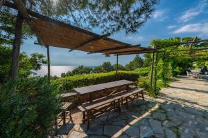 a picnic table under a canopy with a view of the water at Il Carrubo Capri in Anacapri