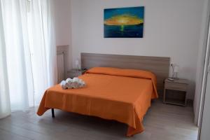 a bedroom with a bed with an orange blanket at B&B ELI in Rodi Garganico