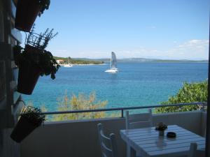 barca a vela in acqua con tavolo sul balcone di Apartment Lara a Žman