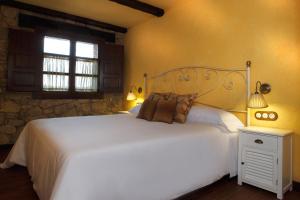 Un dormitorio con una gran cama blanca y una ventana en Casas Rurales Los Ánades, en Abánades