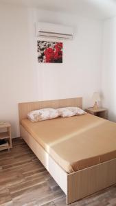 una cama en una habitación con una pared blanca en Casa la Petcu, en Costinesti