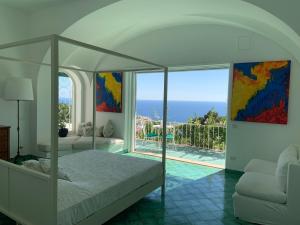 a bedroom with a bed and a view of the ocean at Il Carrubo Capri in Anacapri
