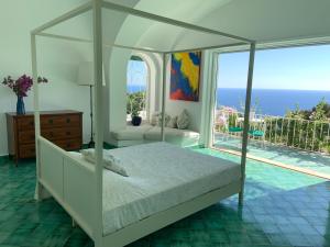 a bedroom with a bed and a view of the ocean at Il Carrubo Capri in Anacapri