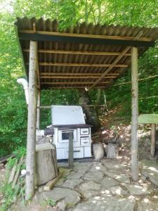 a stove under a wooden roof in a yard at Zlatar Lake - cottage in Kokin Brod