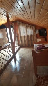 Habitación con cama, TV y techo de madera. en Casa la Petcu, en Costinesti