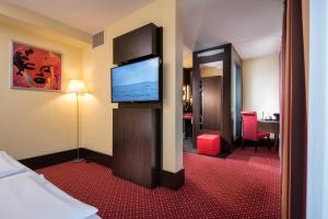 a hotel room with a television on the wall at Best Western Plaza Hotel Hamburg in Hamburg