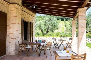 un patio al aire libre con mesas y sillas de madera en Sottocastello Il Casale en Osimo