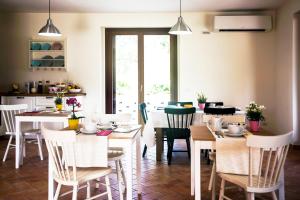 un comedor con mesas y sillas blancas en Sottocastello Il Casale en Osimo