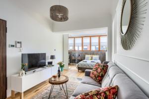 a living room with a couch and a tv at Aparthotel Pawia Deluxe in Warsaw