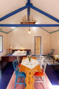 a room with a table and chairs and a bed at Cirkus Hostel Holken in Inkoo