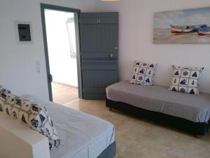 ein Schlafzimmer mit 2 Betten und eine Tür mit einem Fenster in der Unterkunft Infinity Apartments in Naxos Chora
