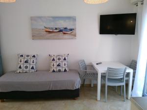 Schlafzimmer mit einem Bett, einem Tisch und einem TV in der Unterkunft Infinity Apartments in Naxos Chora