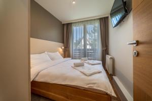 Schlafzimmer mit einem Bett, einem TV und einem Fenster in der Unterkunft Vila Valentina in Zlatibor