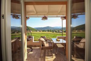 a porch with a table and a view of a field at Holiday house Leona in Otočac