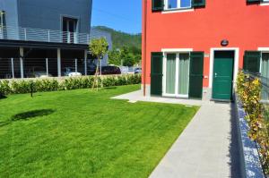 un edificio rojo con una puerta verde y un patio en Liguria Village en Brugnato