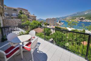 a balcony with a table and chairs and a view of the water at Kazanegra Exclusive Apartments in Sveti Stefan
