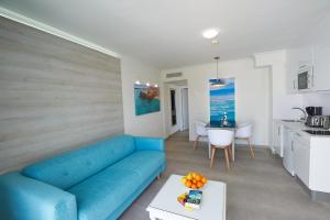 a living room with a blue couch and a table at Hotel Suite Montana Club in Puerto del Carmen