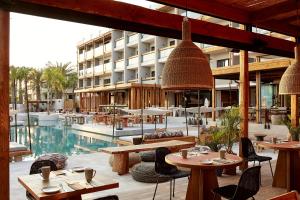a hotel with tables and chairs and a pool at The Syntopia Hotel - Adults Only in Adelianos Kampos